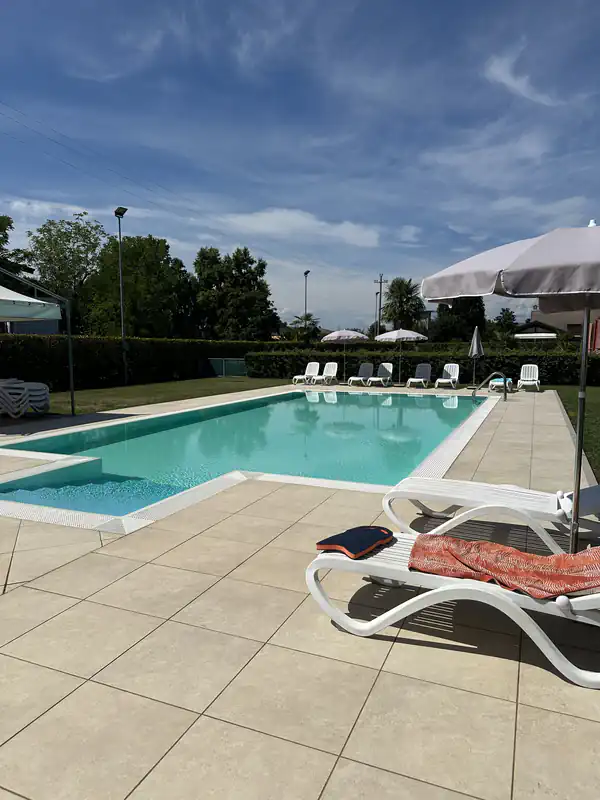 Piscina privata dell'Agriturismo Al Buttasella con ombrelloni e circondata dalla natura a Lavariano di Mortegliano (UD).