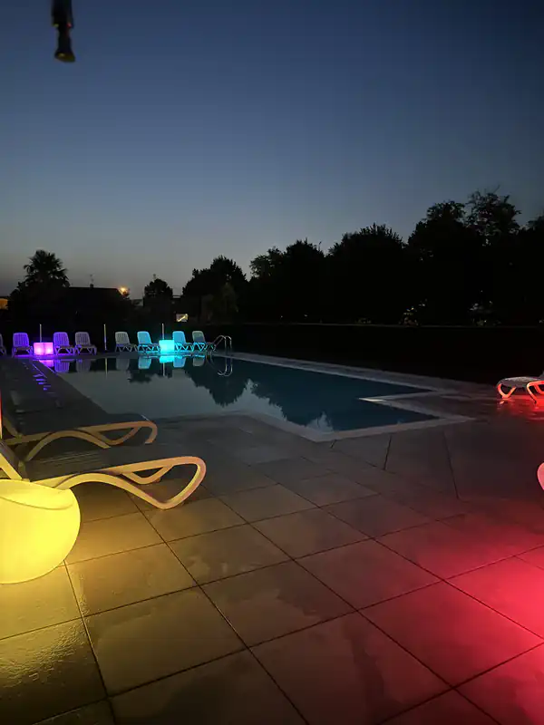 Piscina di notte dell'Agriturismo Al Buttasella con cubi colorati a Lavariano di Mortegliano (UD).