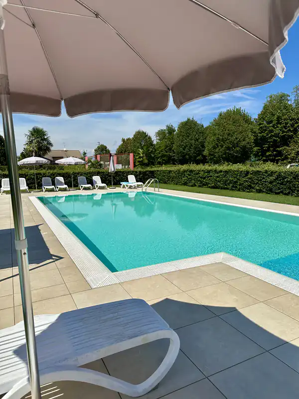 Piscina all'aperto dell'Agriturismo Al Buttasella con ombrelloni a Lavariano di Mortegliano (UD).